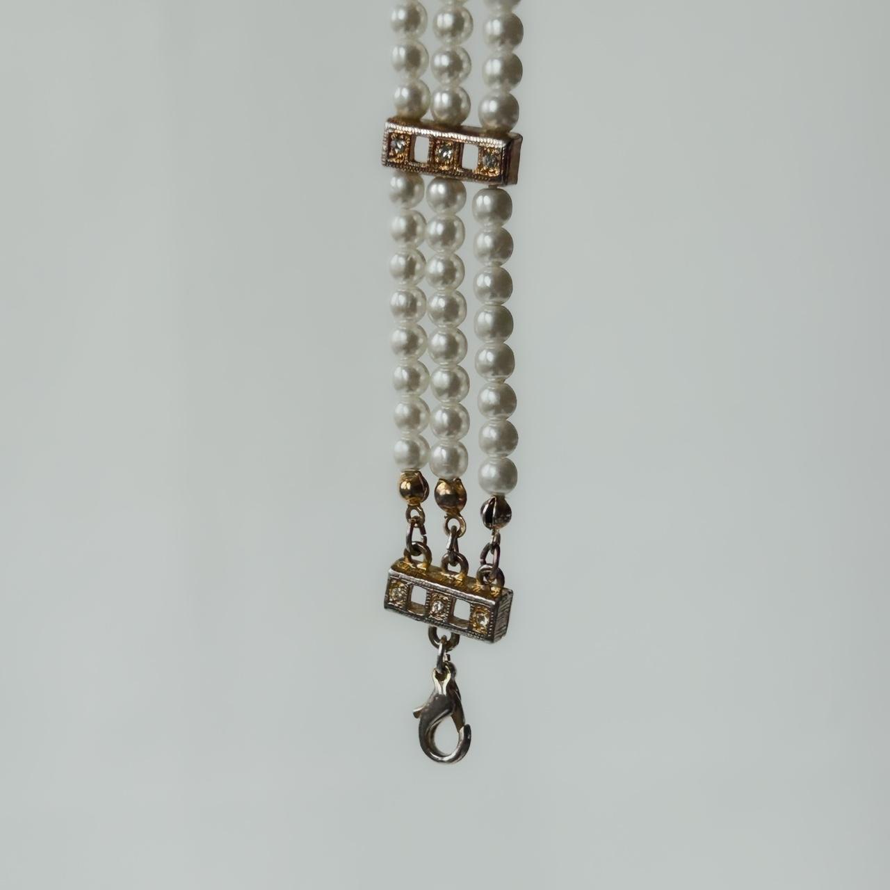 Faux pearl and golden bracelet with rhinestones