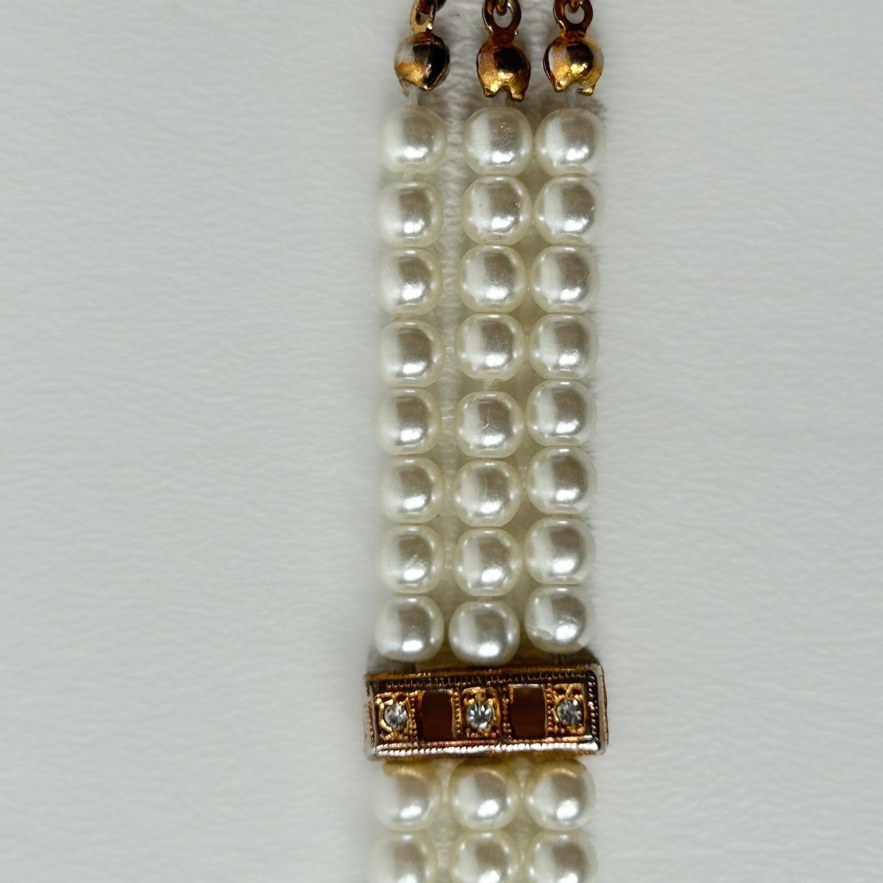 Faux pearl and golden bracelet with rhinestones