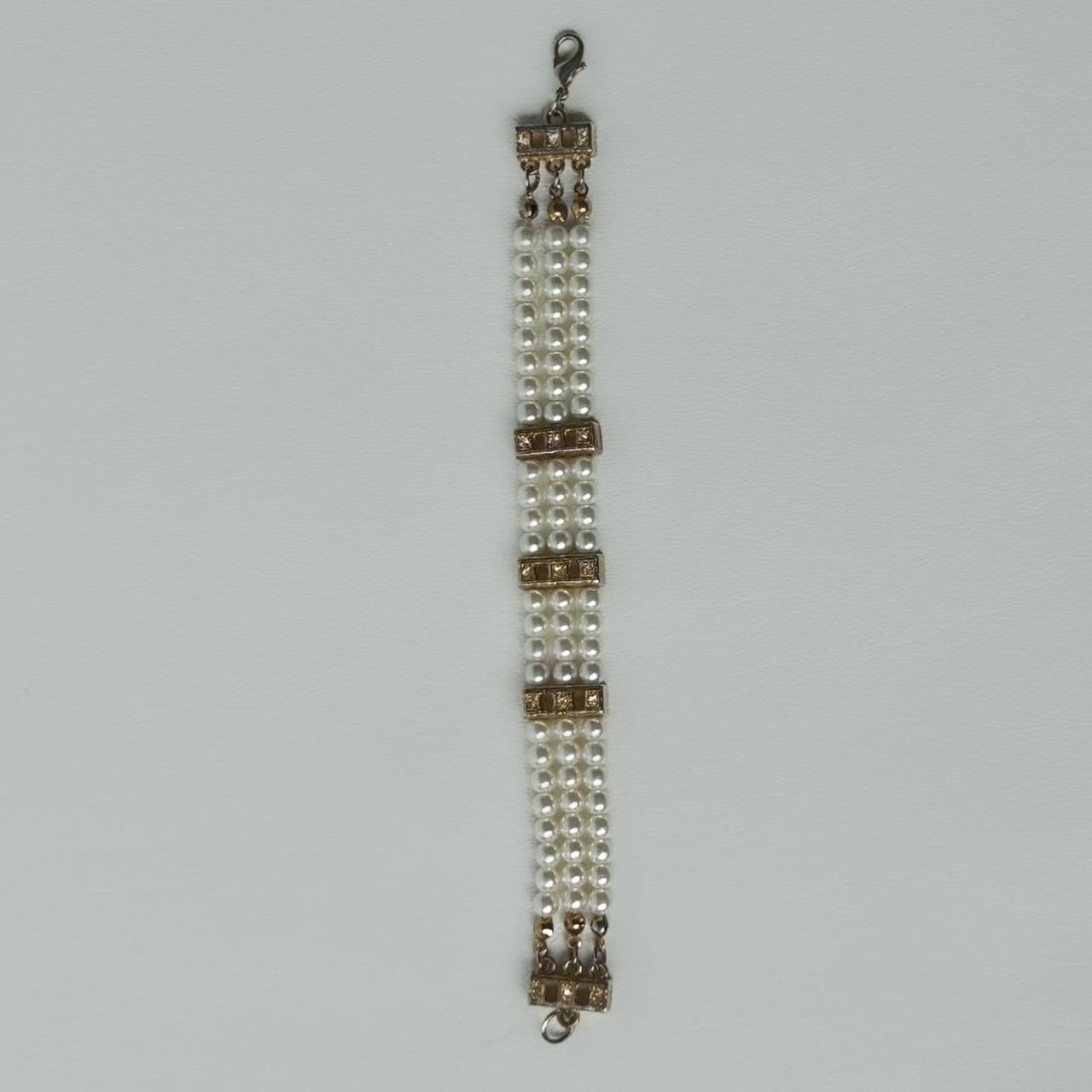 Faux pearl and golden bracelet with rhinestones