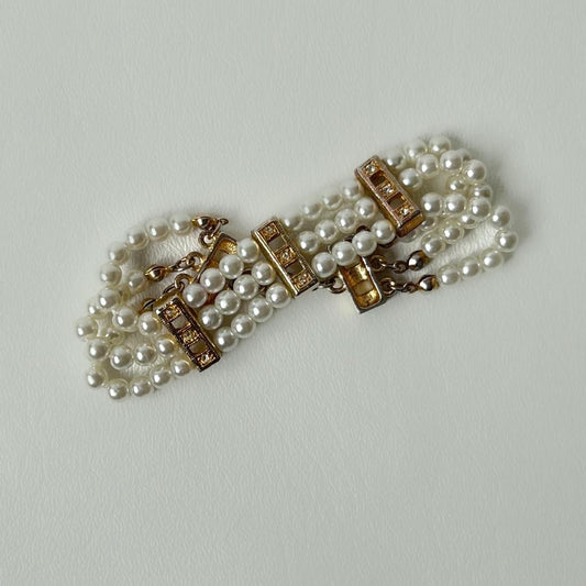 Faux pearl and golden bracelet with rhinestones